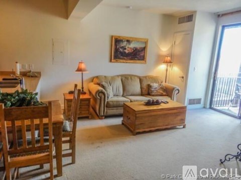 A living room with a couch, chair, and a painting on the wall.