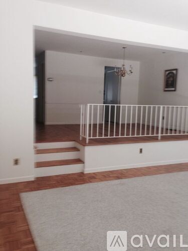 A room with a white wall and a wooden floor.