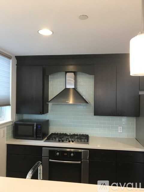 A kitchen with black cabinets and a white countertop.