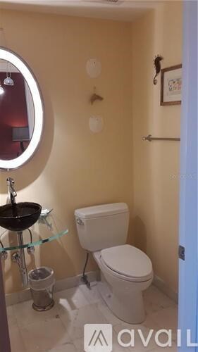 A small bathroom with a toilet, sink and a mirror.