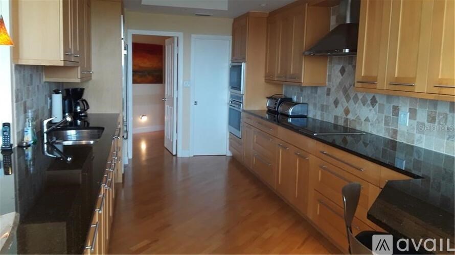 A kitchen with wooden cabinets and black countertops.