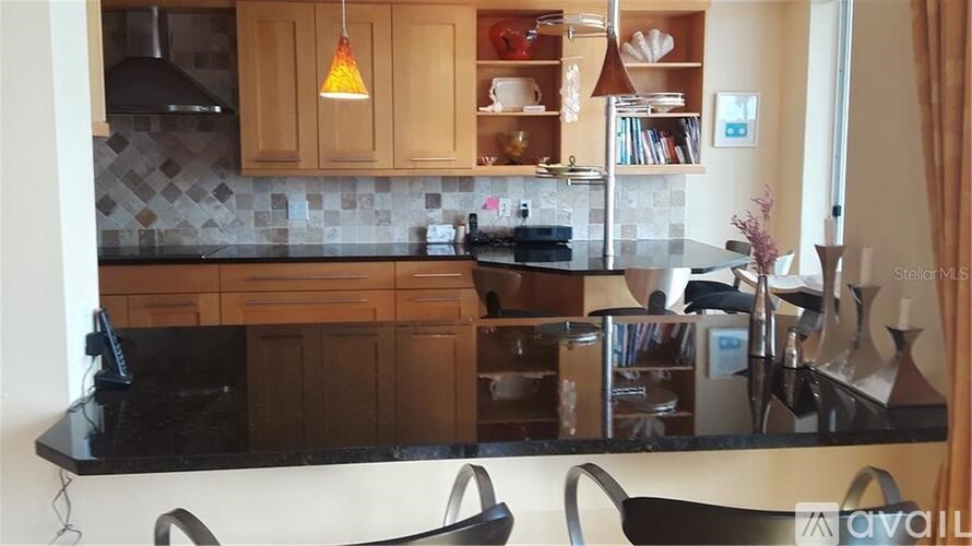 A kitchen with wooden cabinets and black countertops.