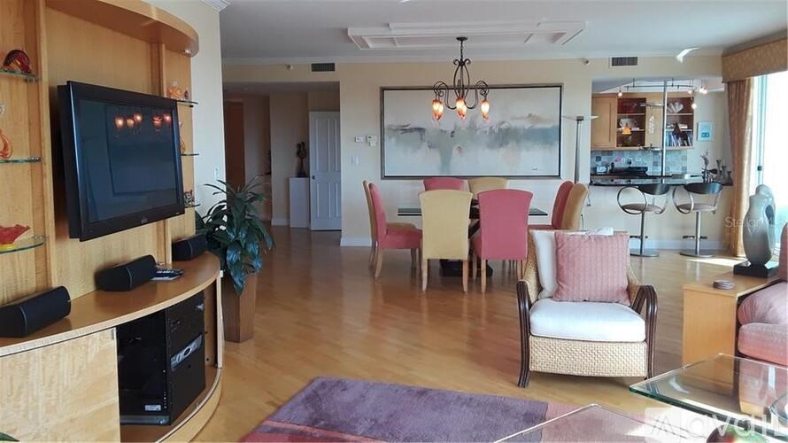 A living room with a television, chairs, and a dining table.