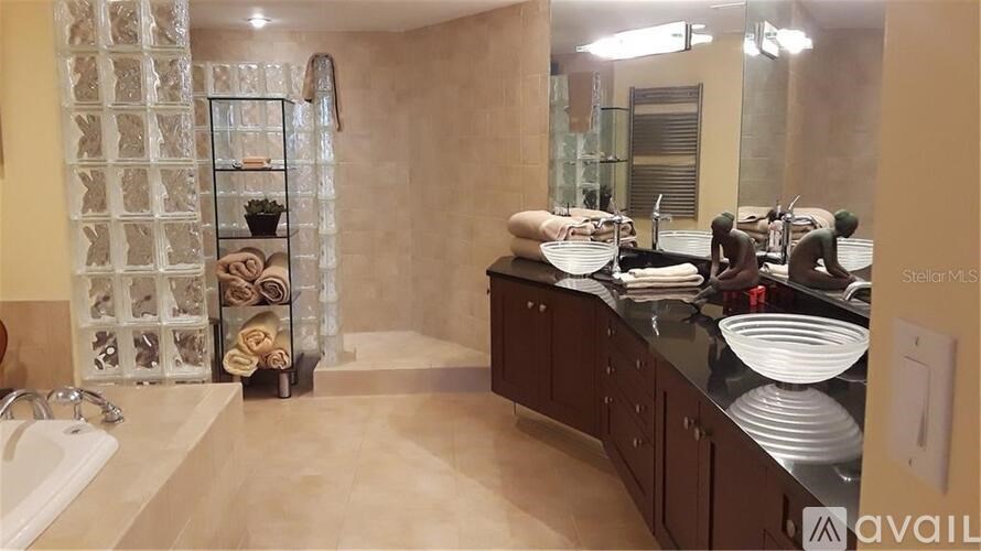 A bathroom with a glass block wall and a sink.