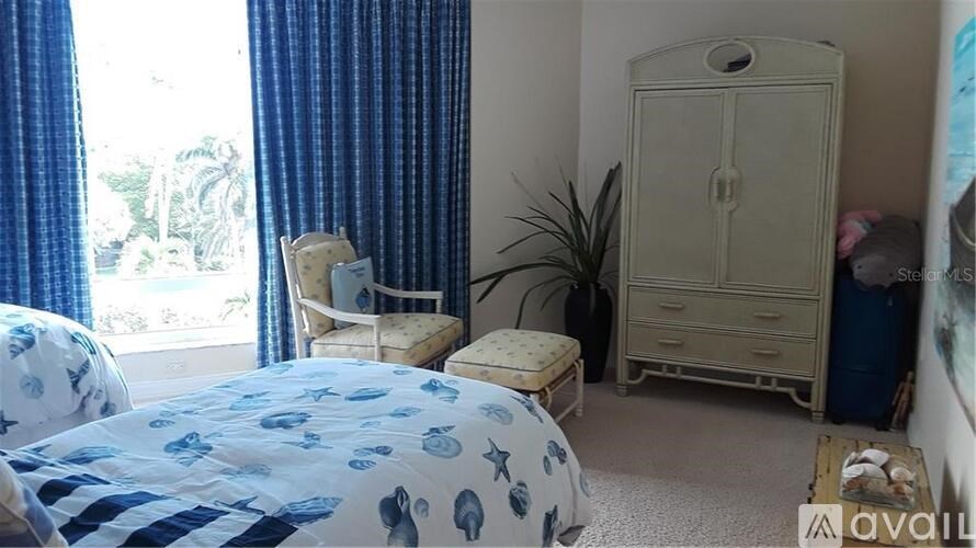 A bedroom with a bed, chair, and wardrobe.