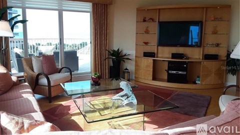 A living room with a glass table and a television on a wooden stand.