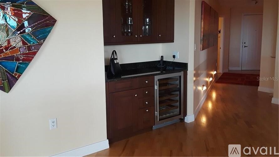 A kitchen with dark wood cabinets and a black countertop.