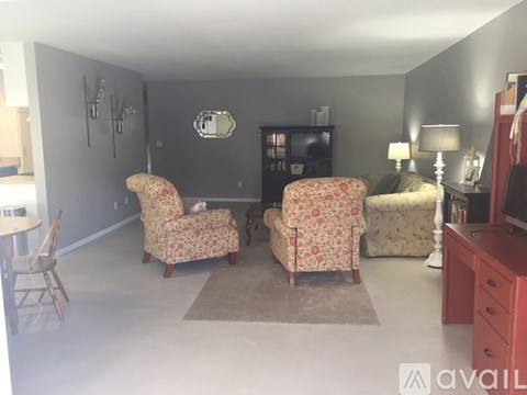 A living room with two floral chairs and a sofa.