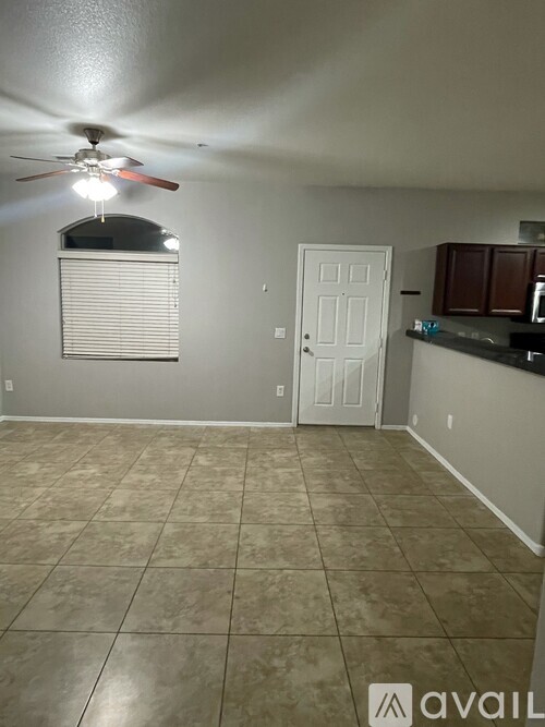 A room with a ceiling fan and a door.