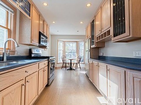 A kitchen with wooden cabinets and a black countertop.