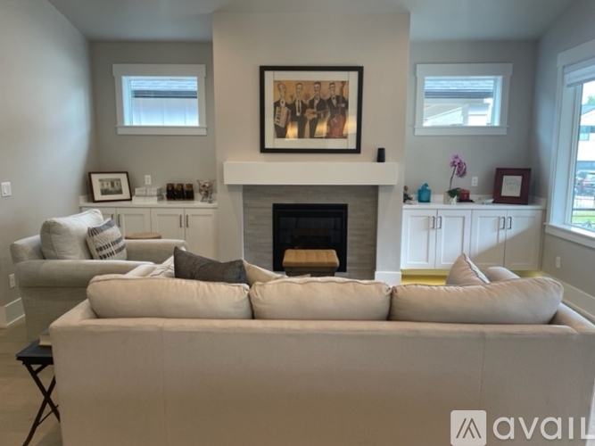 A living room with a fireplace and a large painting above it.