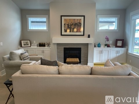 A living room with a fireplace and a large painting above it.