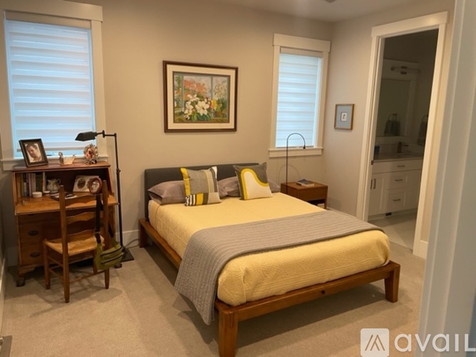 A bedroom with a bed, nightstand, and chair.