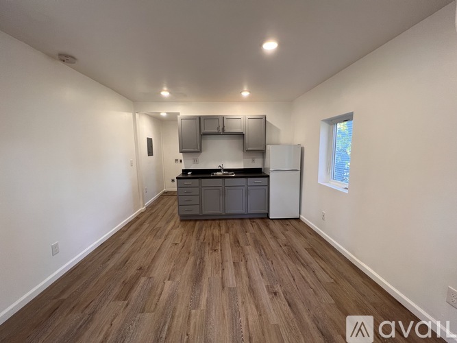 A kitchen with wooden floors and white walls.