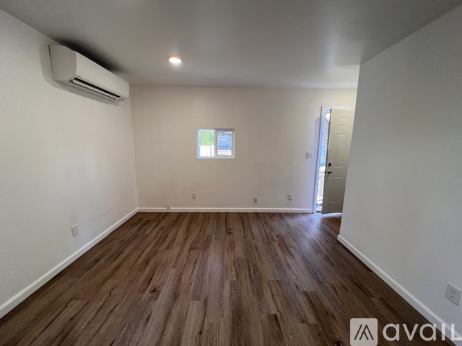 A room with wooden flooring and a window.