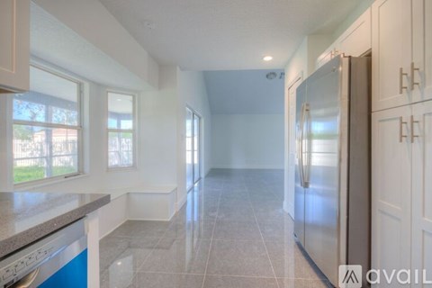 A kitchen with a blue dishwasher and a refrigerator.