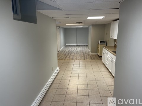 A long hallway with a kitchen area at the end.
