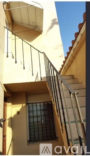 A yellow building with a window and a sign that says "avall".