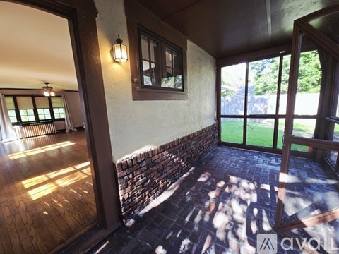 A spacious room with wooden floors and a staircase.