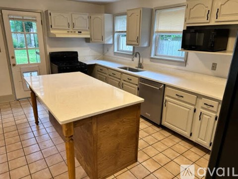 A kitchen with a white counter top and black appliances.
