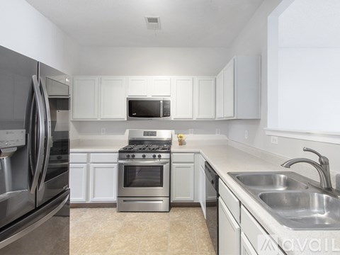 A kitchen with white cabinets and stainless steel appliances.