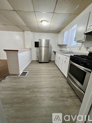 A kitchen with white cabinets and a stainless steel refrigerator.