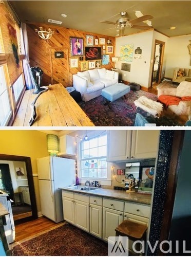 A living room with a couch and a kitchen with a refrigerator.