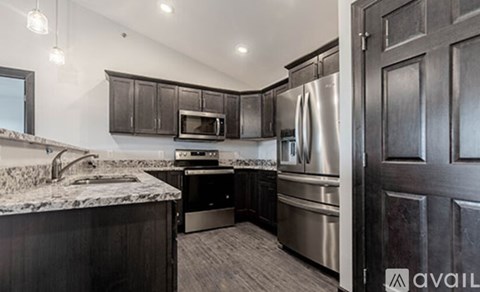 A kitchen with dark wood cabinets and stainless steel appliances.