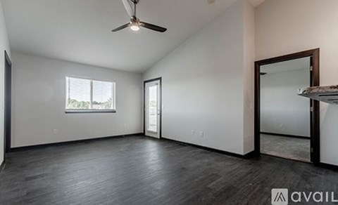 A spacious room with a ceiling fan and a large mirror on the wall.