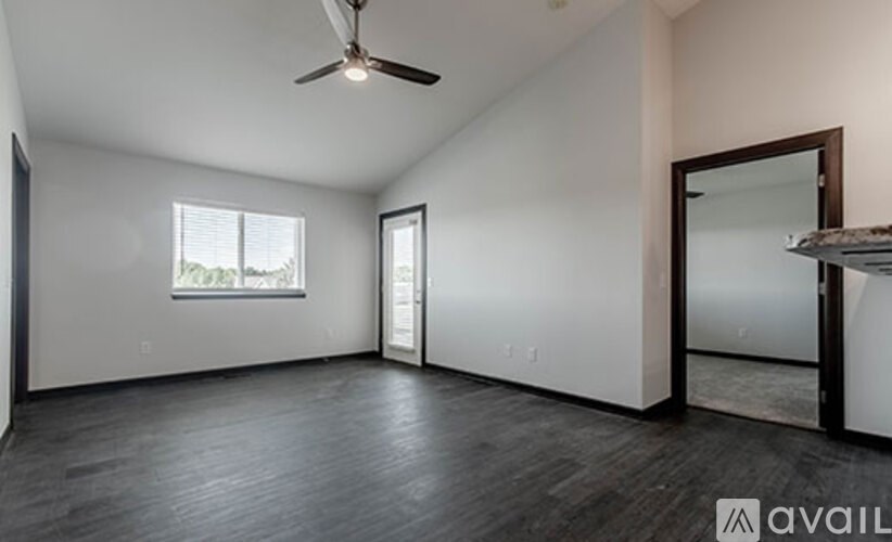 A spacious room with a ceiling fan and a large mirror on the wall.