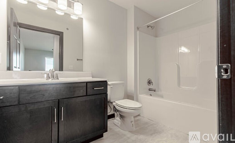 A bathroom with a white toilet and a white bathtub.