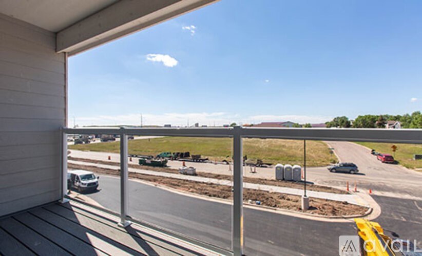 A view from a balcony overlooking a roundabout with cars on it.
