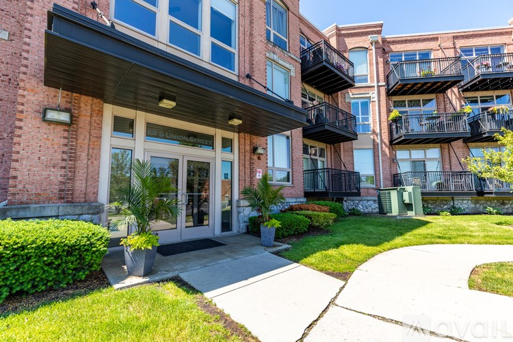 A building with a balcony and a green lawn in front.