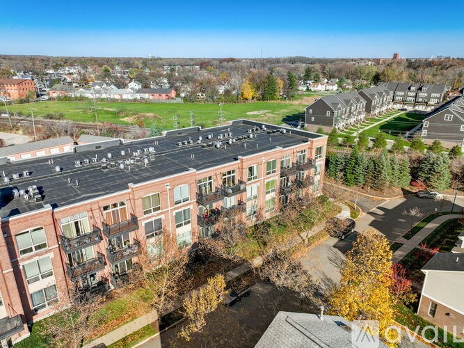 A large apartment complex with a parking lot in front.