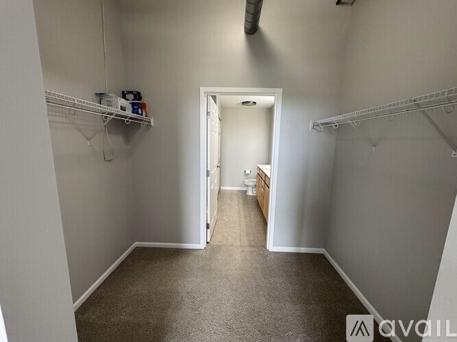 A hallway with a white door and a carpeted floor.