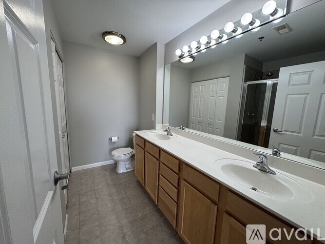 A bathroom with a toilet, sink, and mirror.