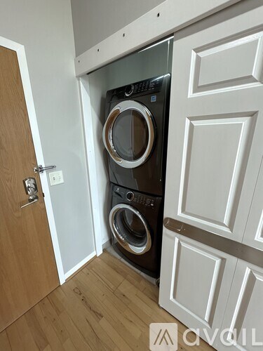 A washing machine is built into a cabinet in a room.