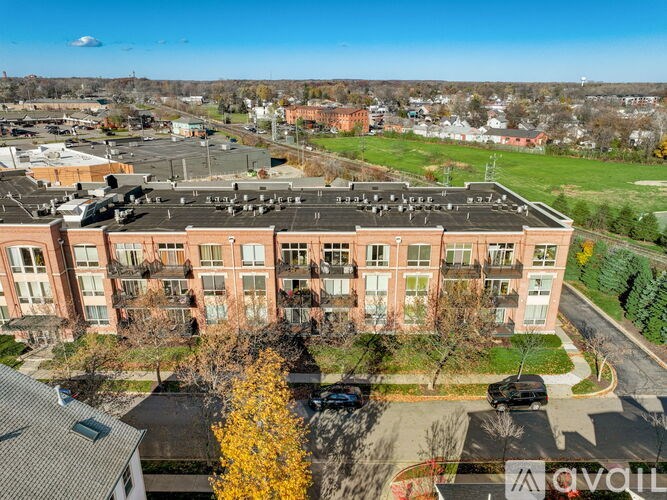 A large red brick building with a parking lot in front.