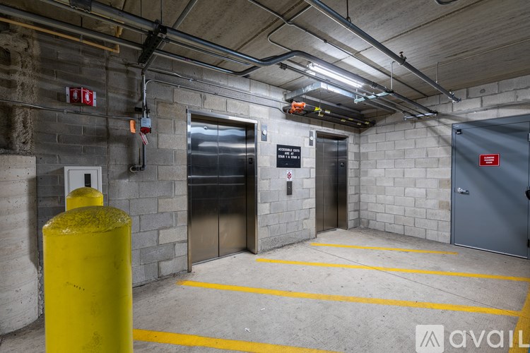 A yellow pole is in the foreground of a parking garage.