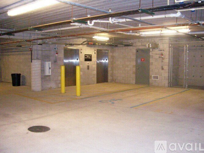 A large, empty parking garage with concrete walls and yellow poles.