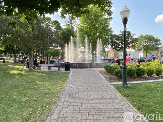 A park with a fountain and a walkway.