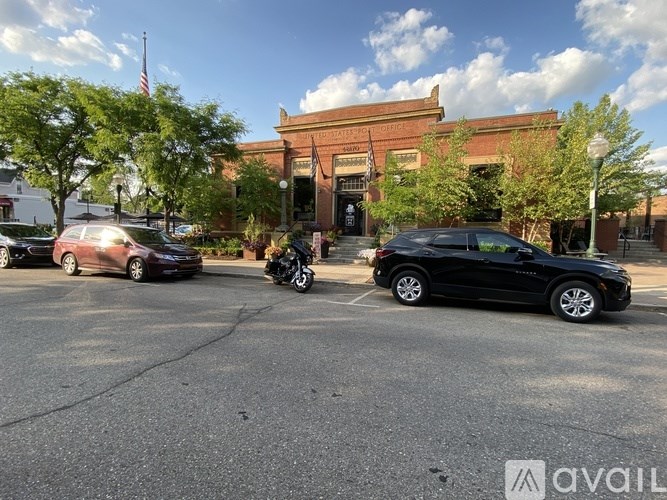 A black car is parked in front of a building with a sign that reads "AVAILABLE".