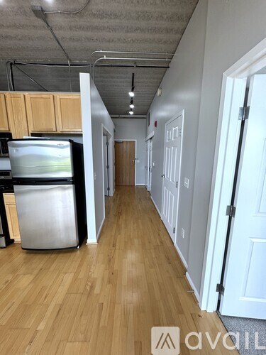 A long hallway with a trash can and a door on the right.