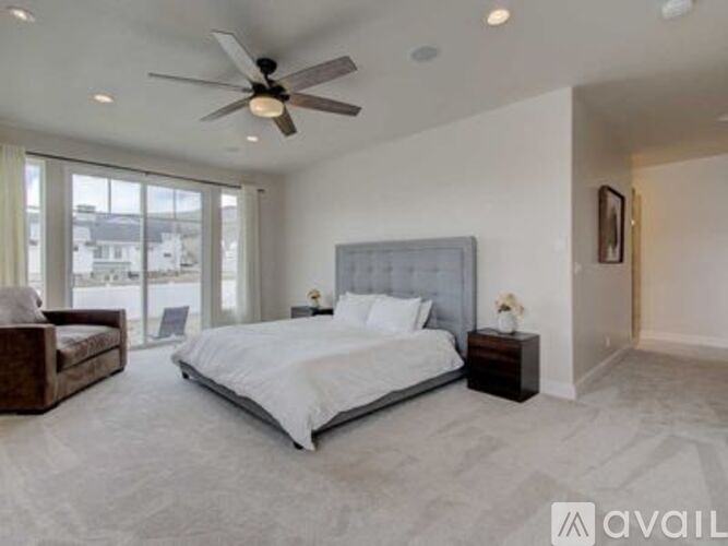 A bedroom with a large bed and a ceiling fan.