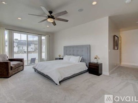 A bedroom with a large bed and a ceiling fan.