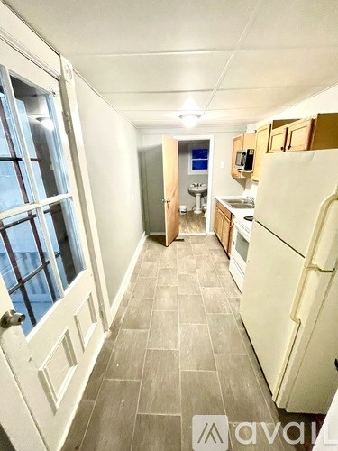 A kitchen with a white fridge and wooden cabinets.