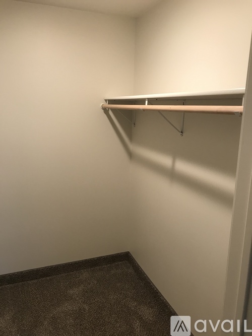 Empty room with a shelf and carpeted floor.