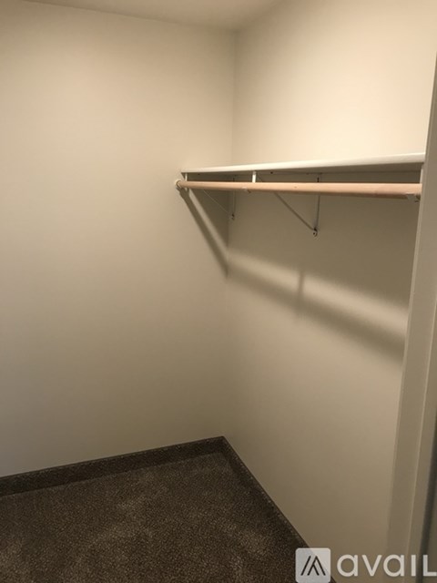 Empty room with a shelf and carpeted floor.