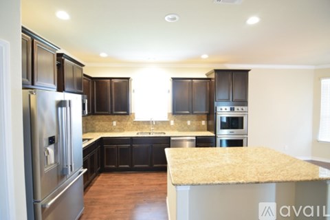 A kitchen with dark wood cabinets and granite countertops.