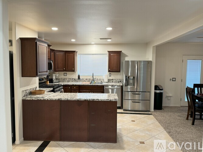 A kitchen with brown cabinets and a marble countertop.